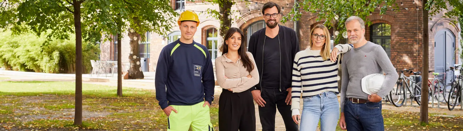 Mitarbeitende aus verschiedenen Bereichen der GASAG-Gruppe stehen unter Bäumen.