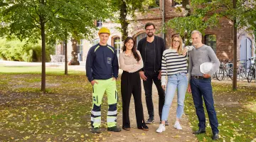 Mitarbeitende aus verschiedenen Bereichen der GASAG-Gruppe stehen unter Bäumen.